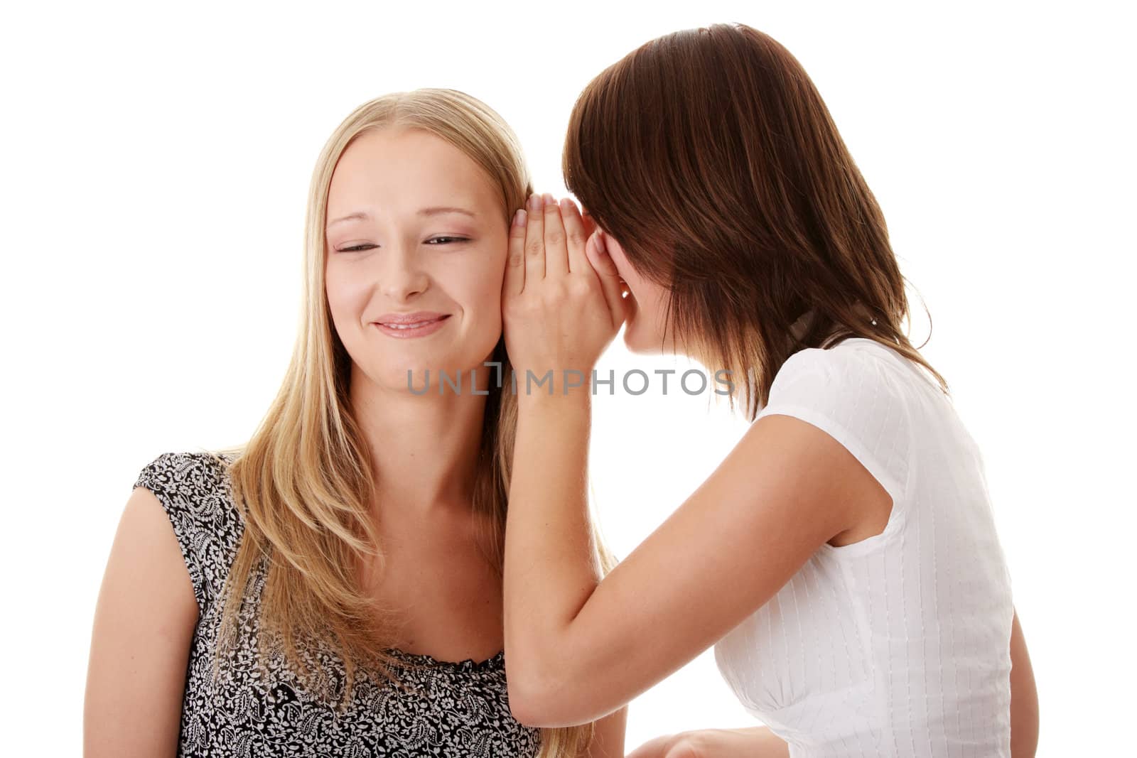 Two young casual caucasian woman gossiping isolated against white background