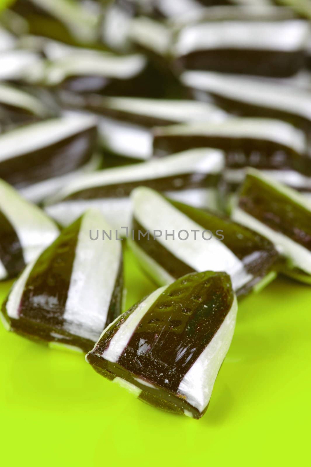 Humbug lollies isolated against a yellow background