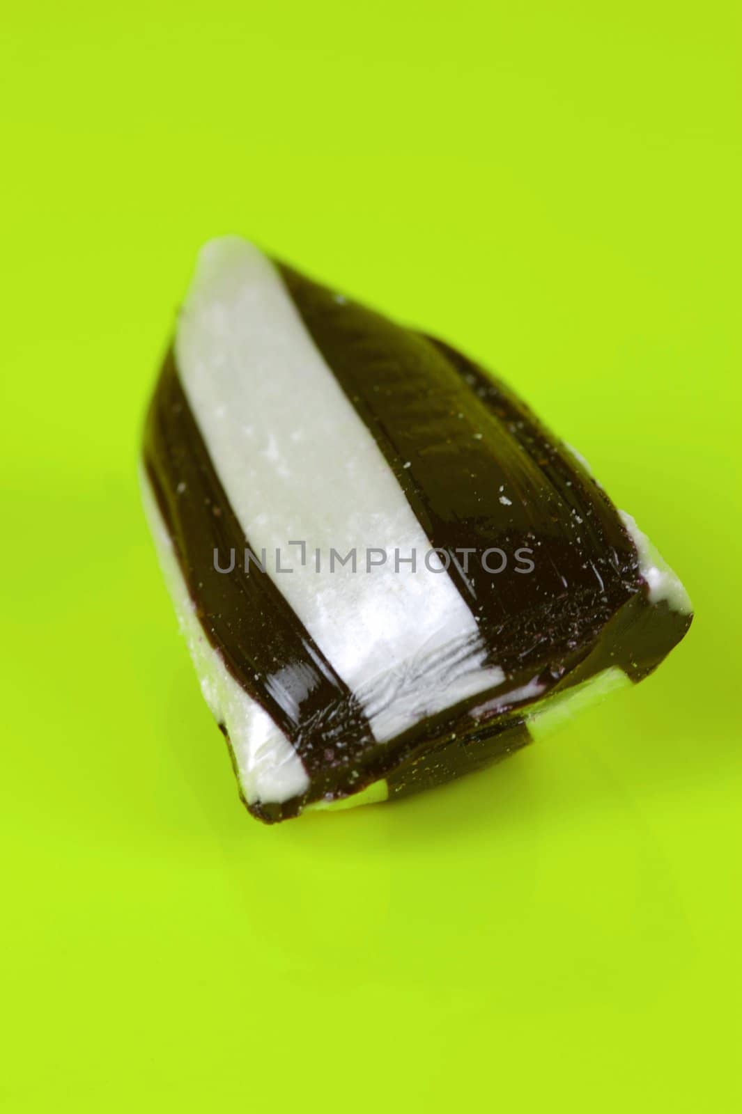 Humbug lollies isolated against a yellow background