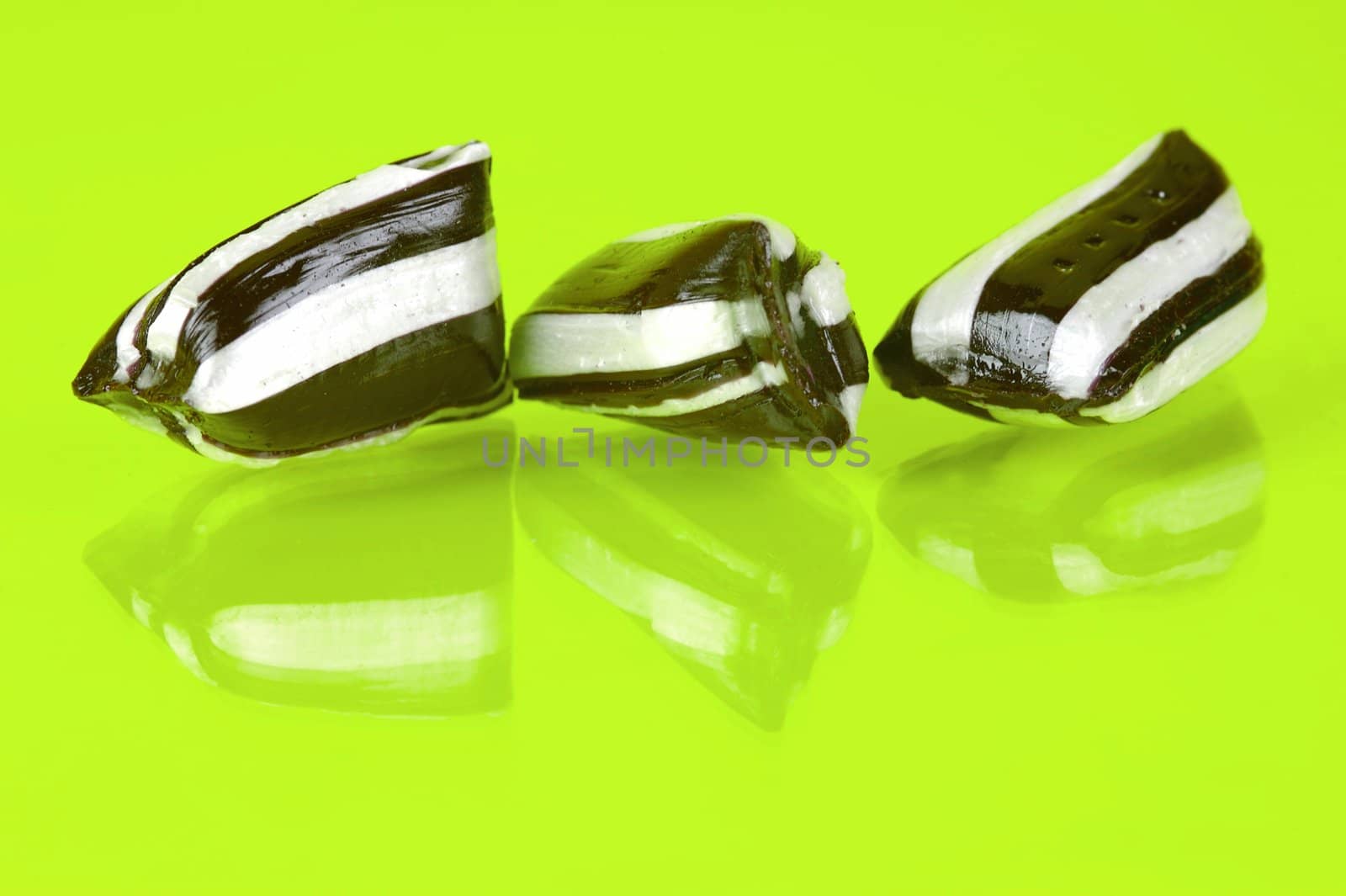 Humbug lollies isolated against a yellow background