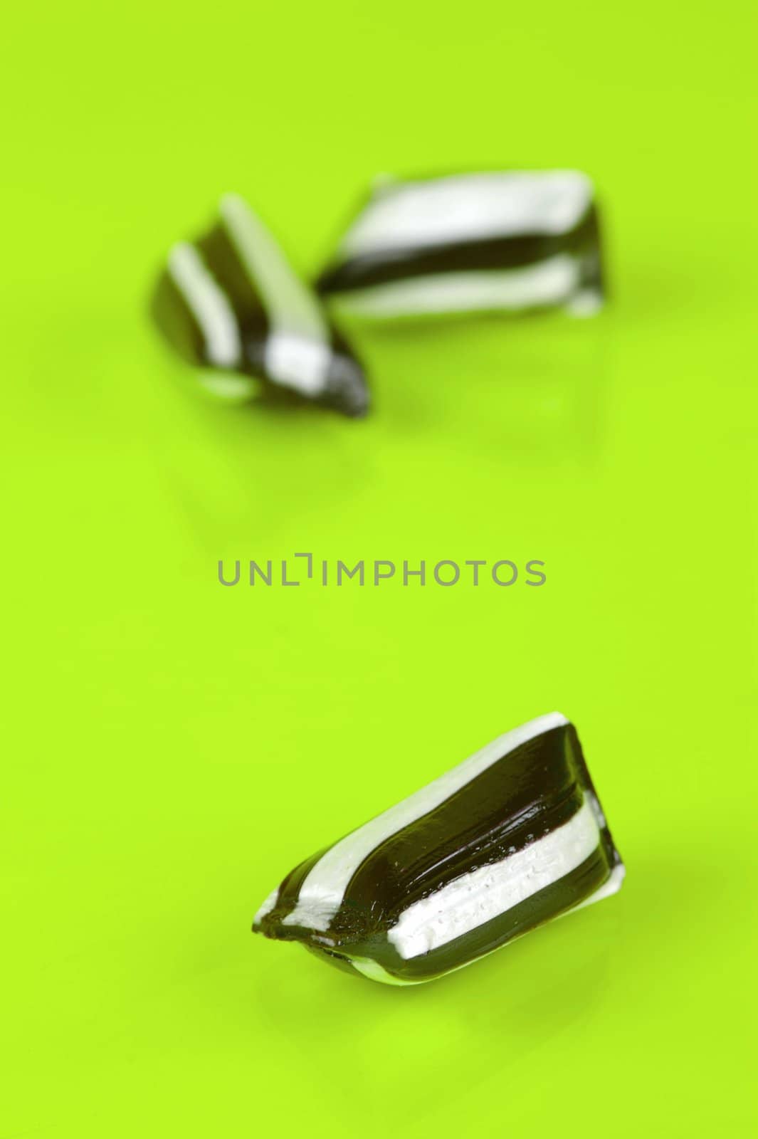 Humbug lollies isolated against a yellow background
