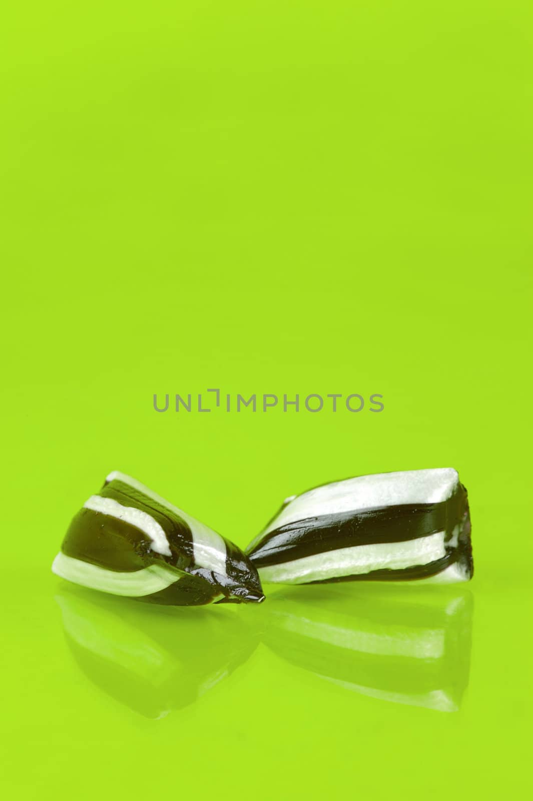 Humbug lollies isolated against a yellow background