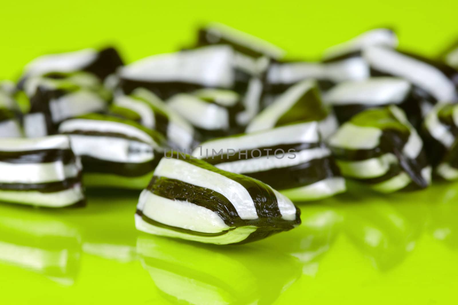 Humbug lollies isolated against a yellow background