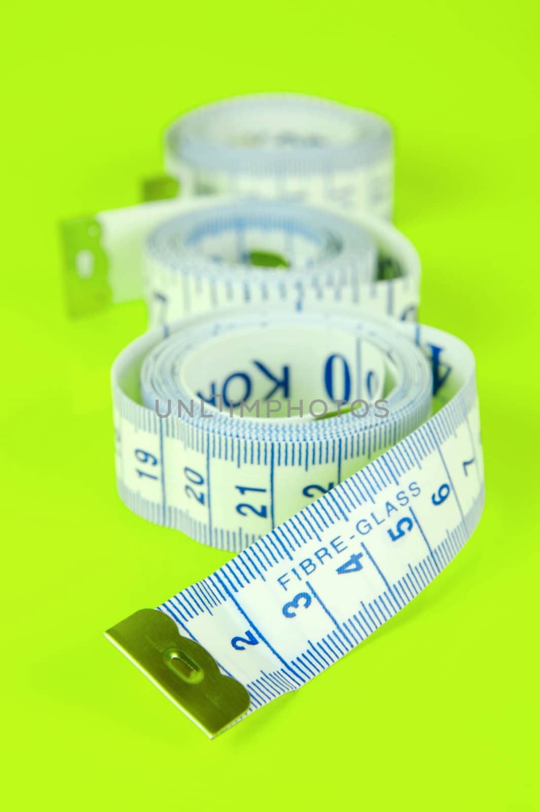 A measuring tape isolated agaist a lime green background