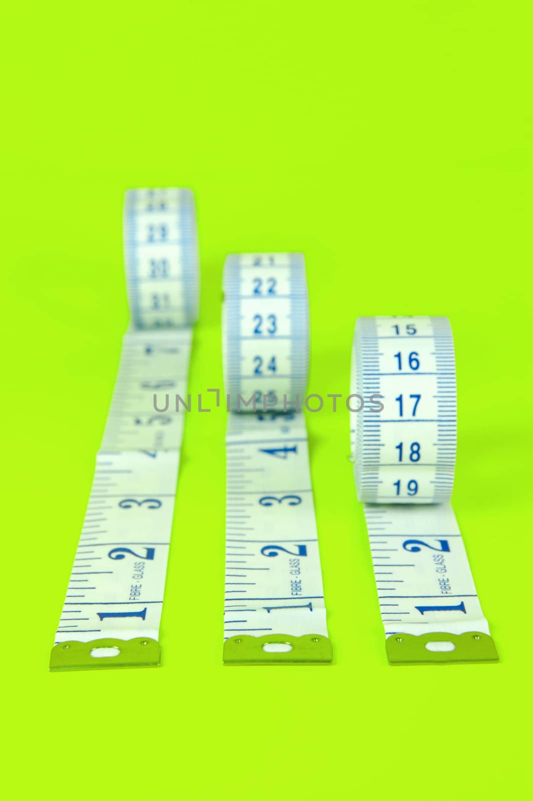 A measuring tape isolated agaist a lime green background