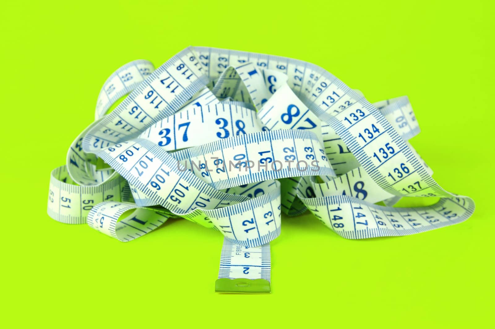 A measuring tape isolated agaist a lime green background