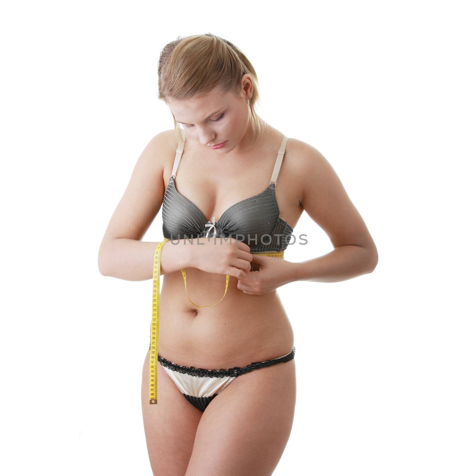 A little bit fat young woman mesuring her body isolated on white background