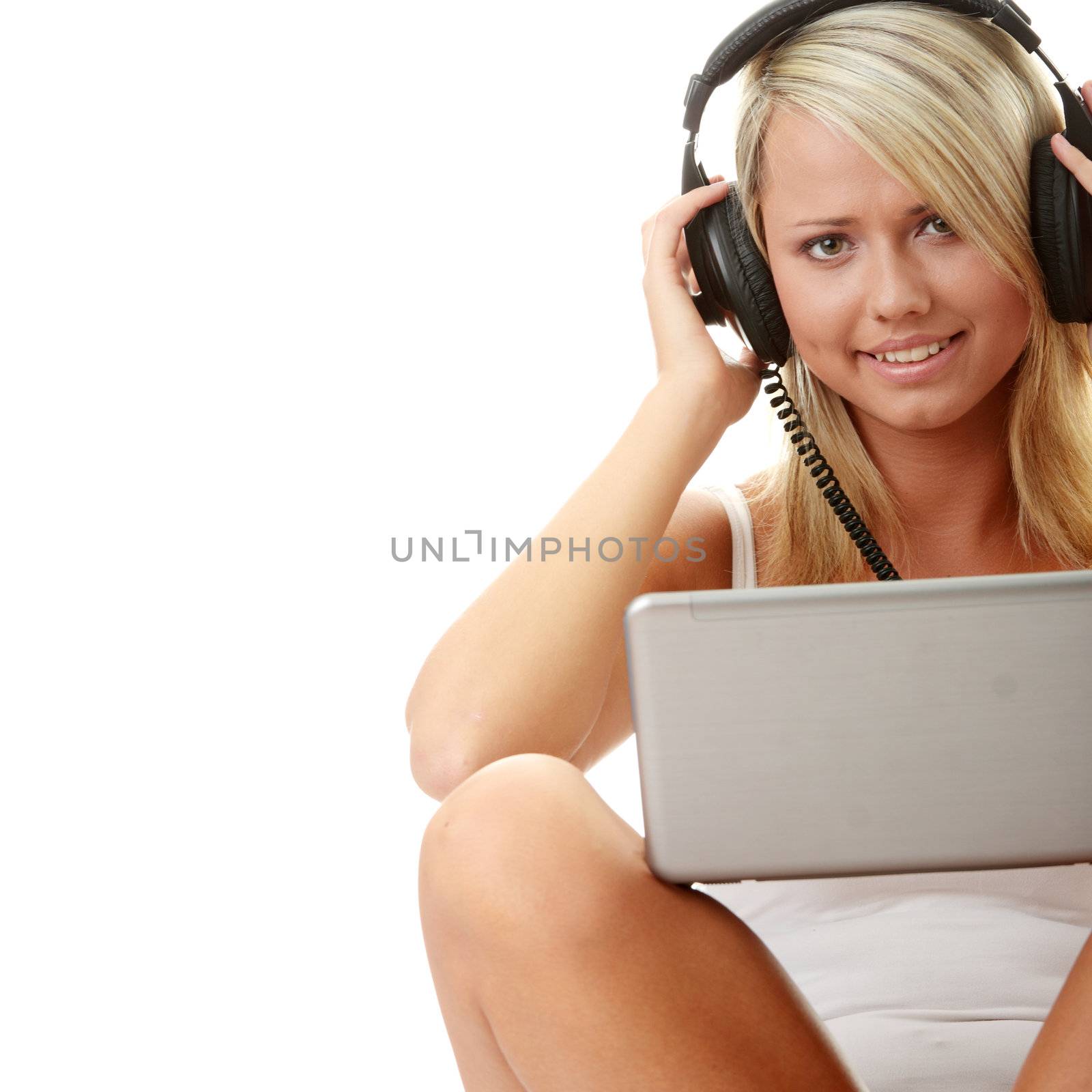 Casual student listening to music on the computer while studying isolated over a white background