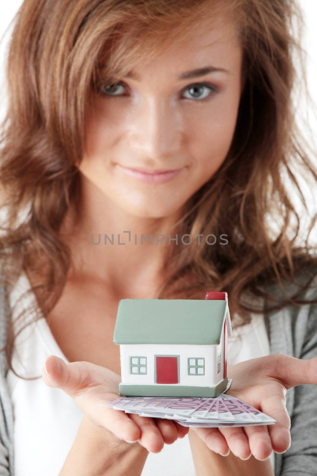 Beautiful young woman holding euros bills and house model over white