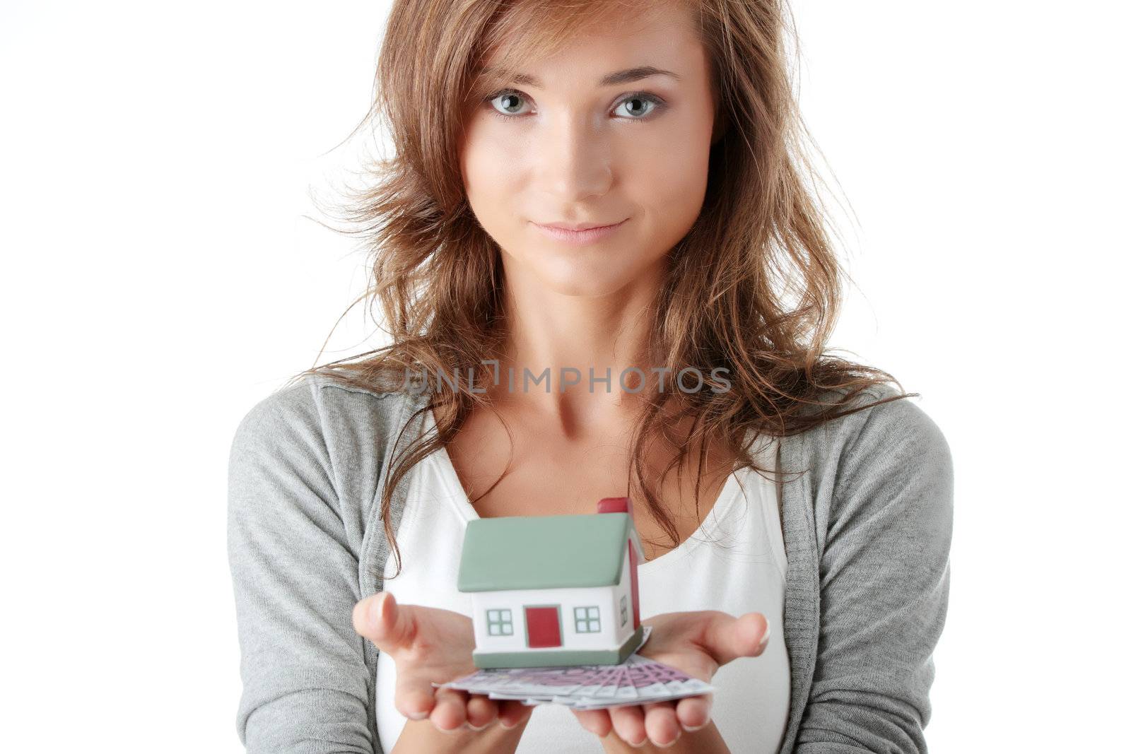 Beautiful young woman holding euros bills and house model over white - real estate loan concept