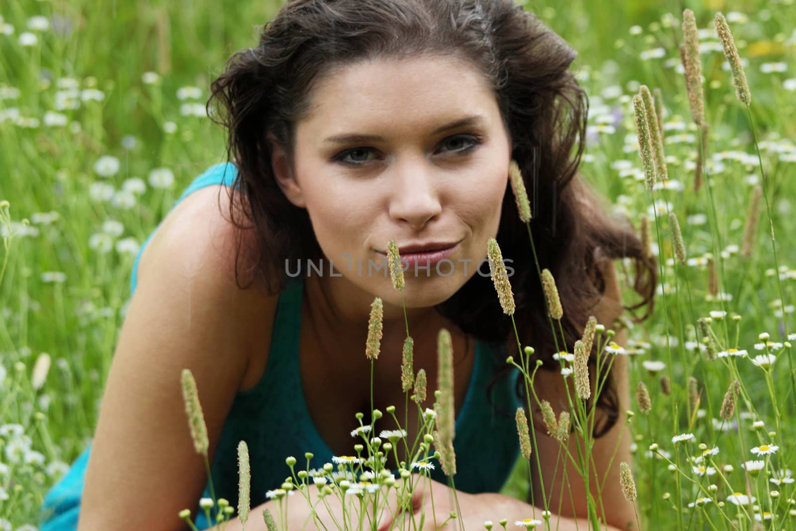 Beautiful young woman relaxing in the grass (rain in summer)