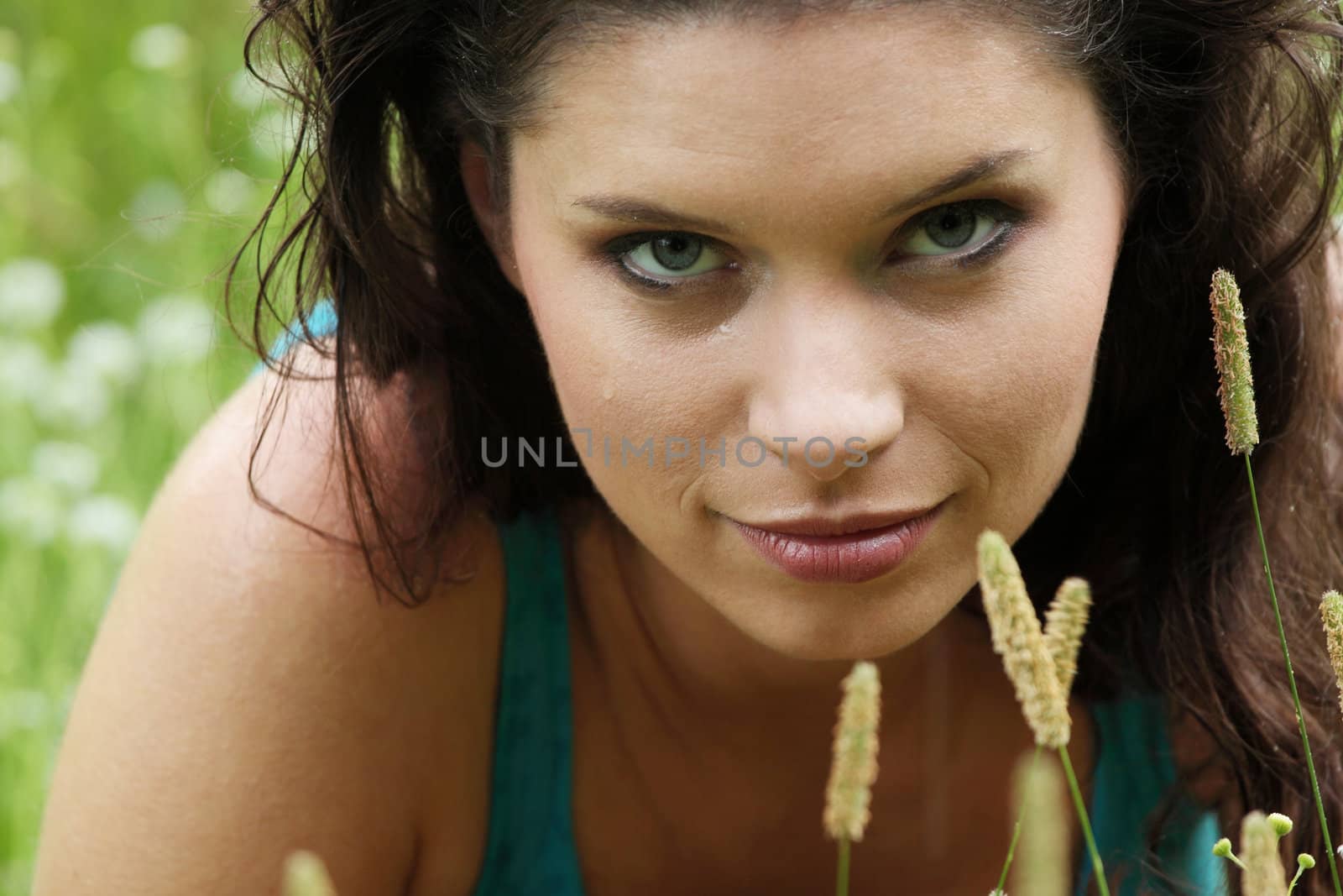 Beautiful young woman relaxing in the grass (rain in summer)