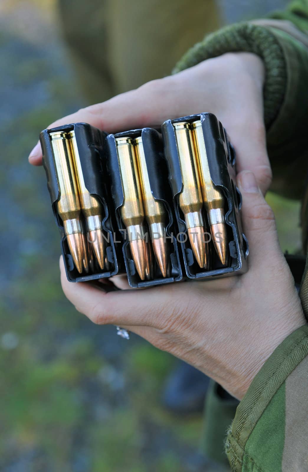 Soldier holding three clips of 7,62x51 nato ammunition