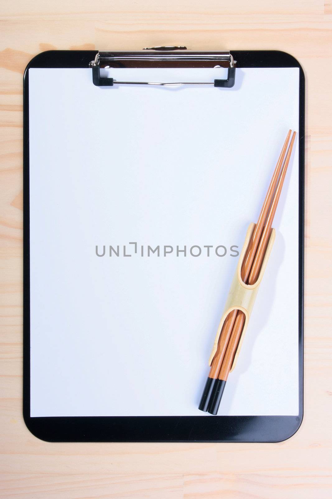 The Chinese chopsticks are placed against bank clipboard.