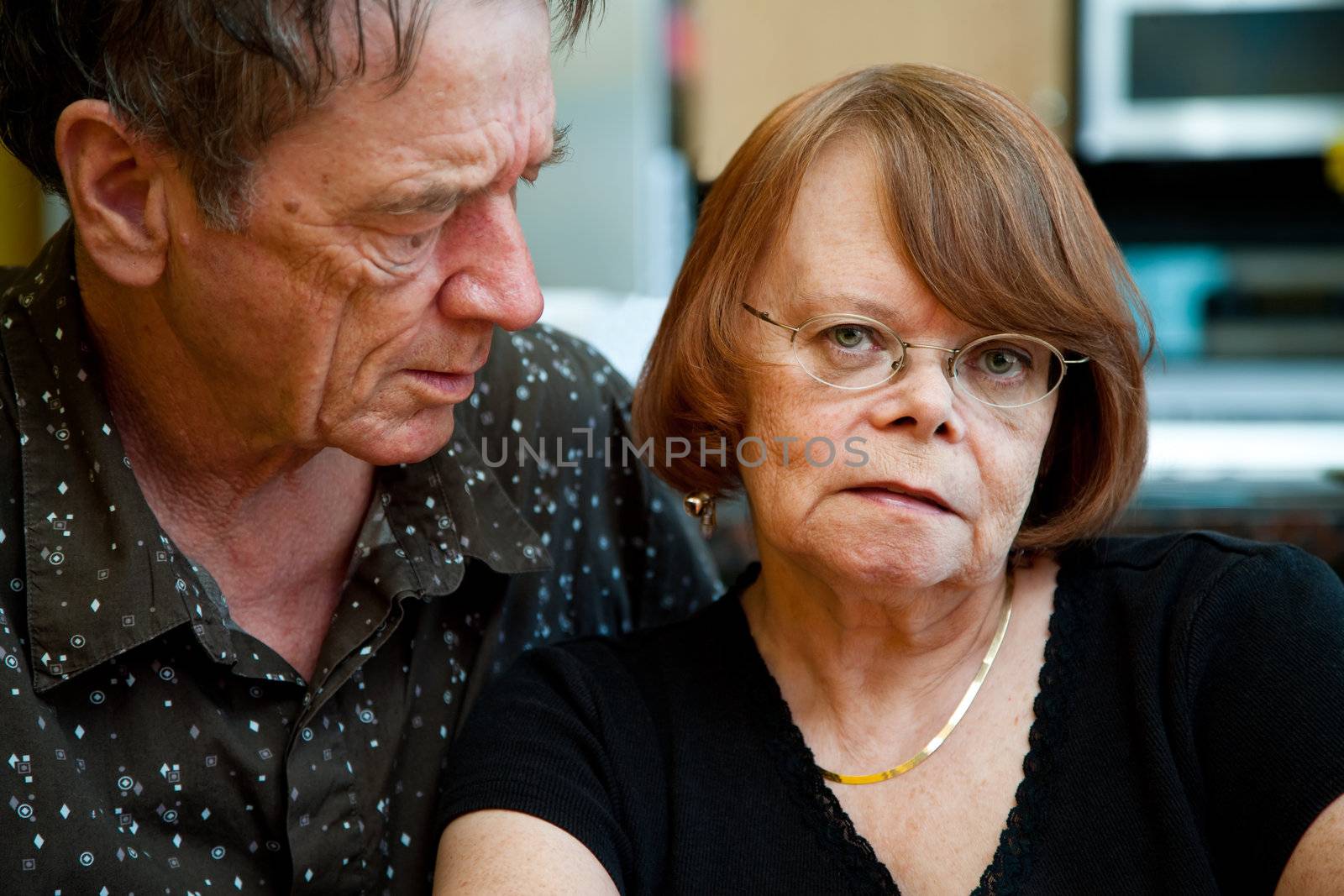 Worried Senior Couple at Home in Modern  Kitchen