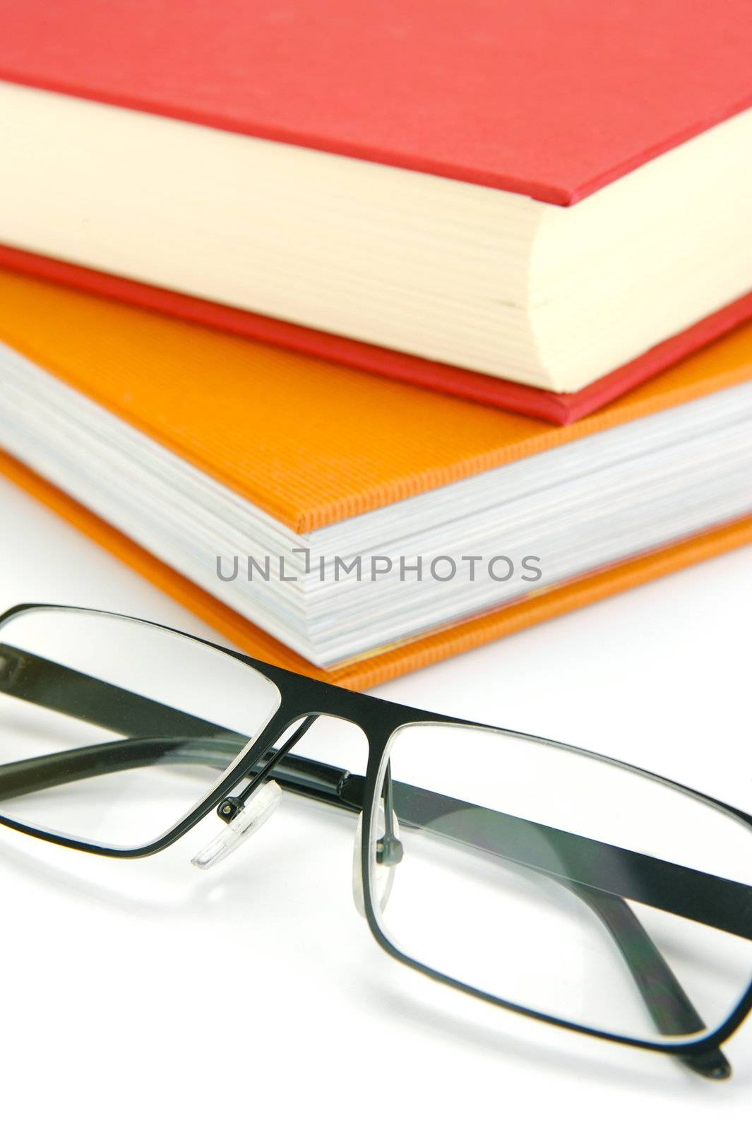 Reading glasses and books isolated against a white background