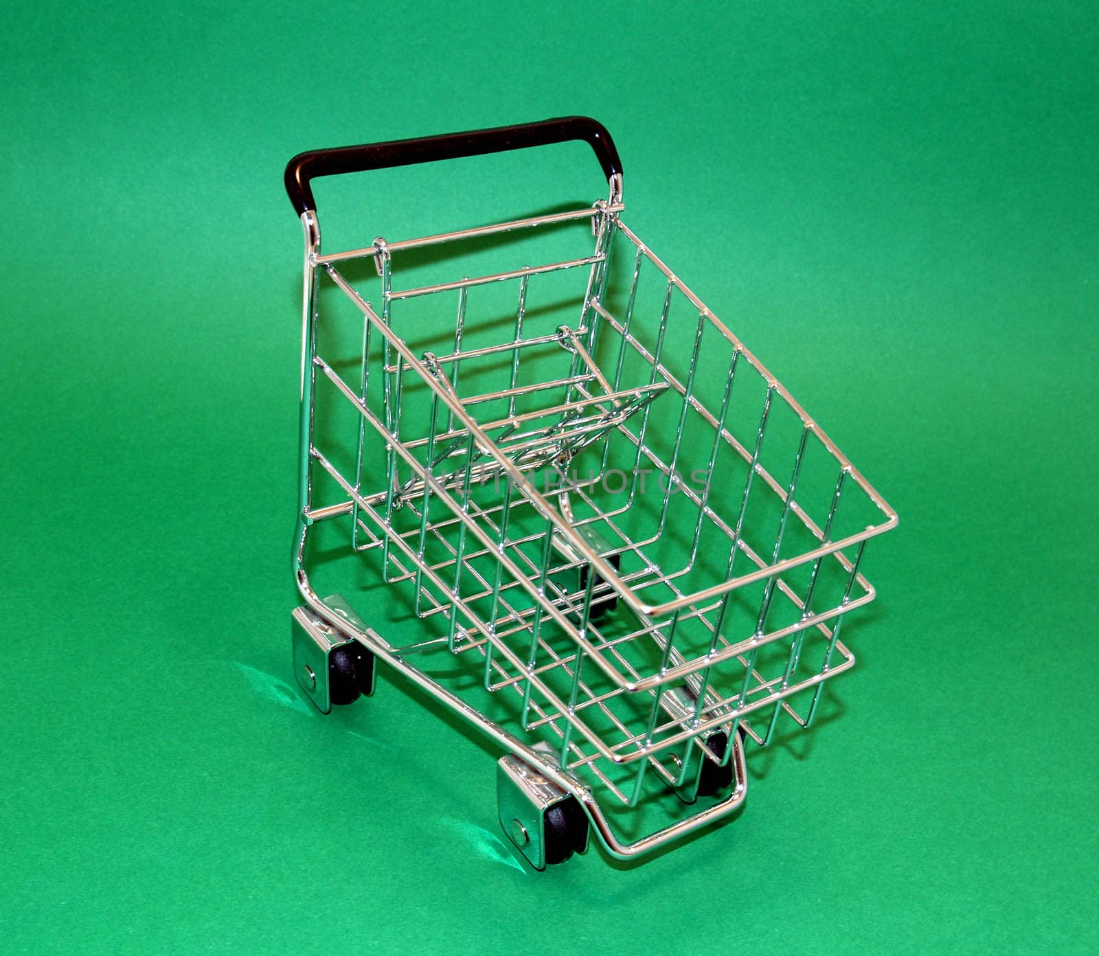 Little shopping cart on a green screen easy to isolate.