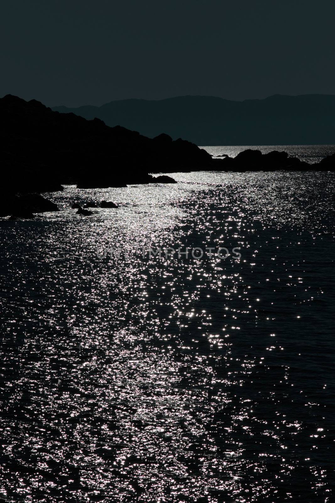 scenic view in kerry ireland of rocks and sea with mountains against a beautiful night sky