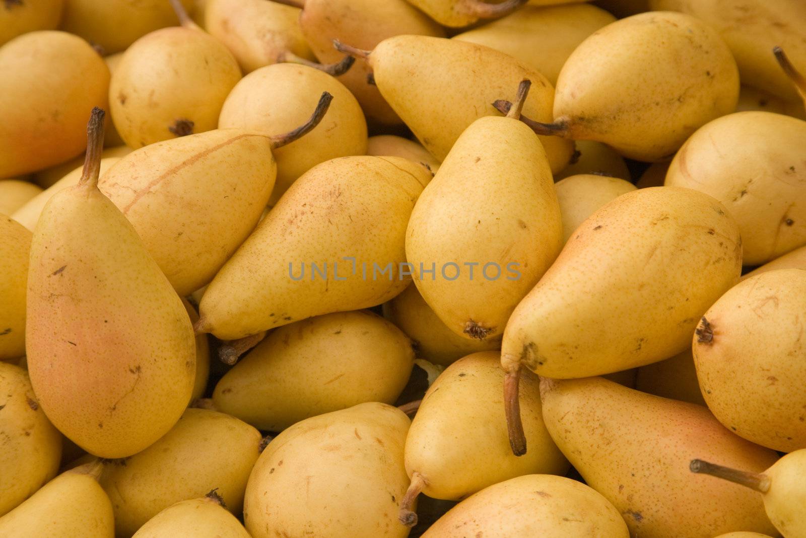 Yellow pears tiled on a market stall.