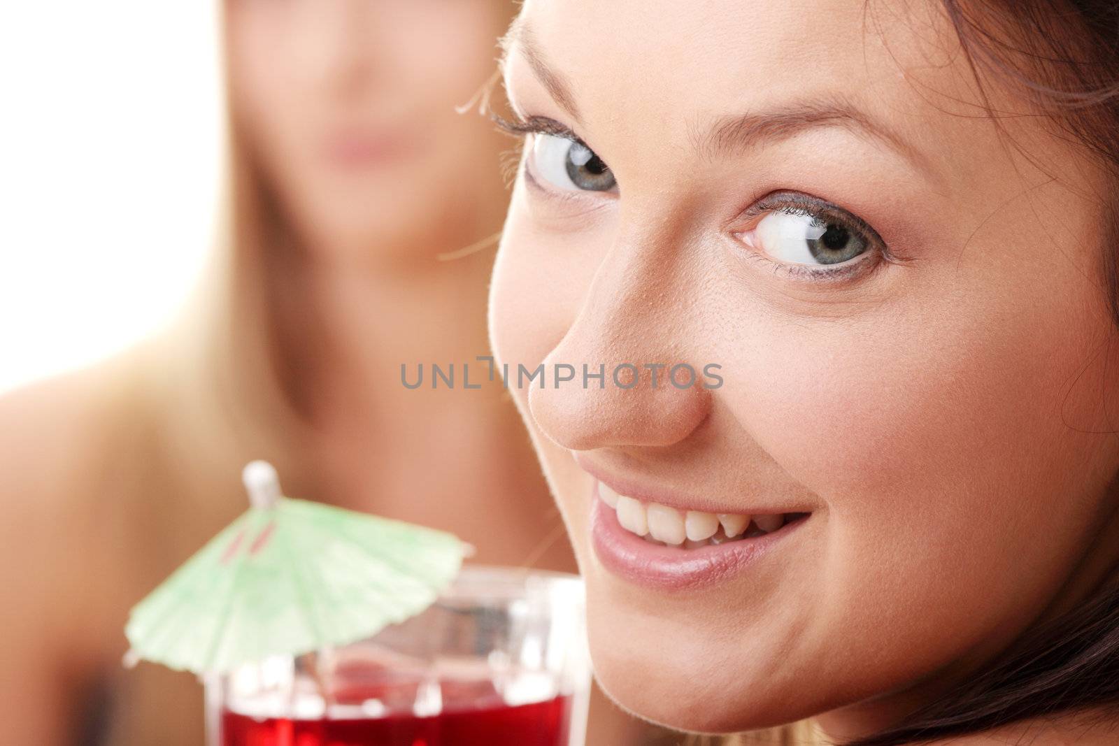 Two girls in bikini drink fruit cocktails isolated on white