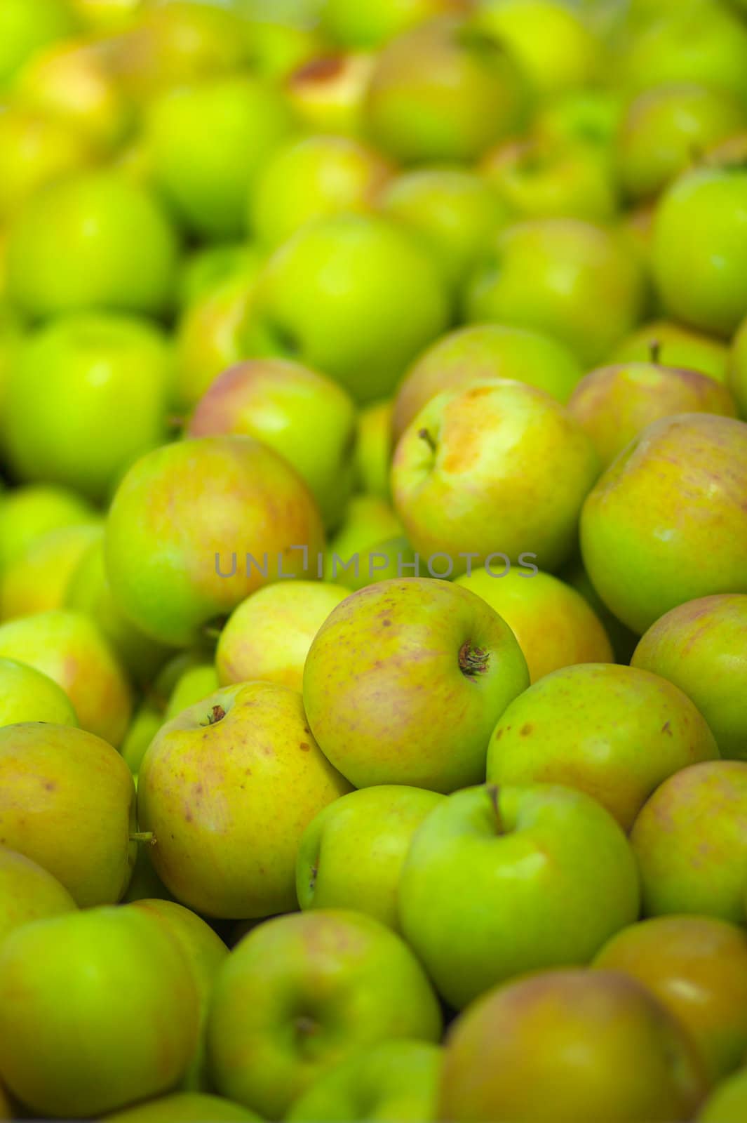 a pile of green apples at a California fruit market with soft focus background
