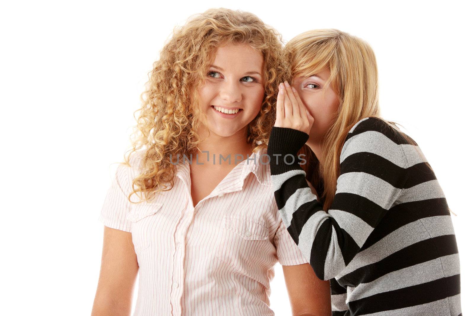 Two happy young girlfriends talking isolated over white