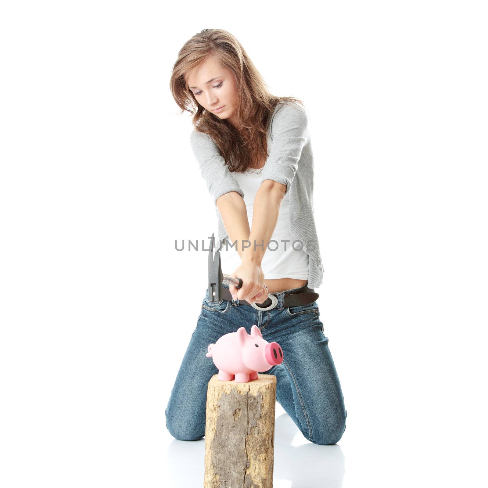 Young woman with hammer about to smash piggy bank to get at corporate savings