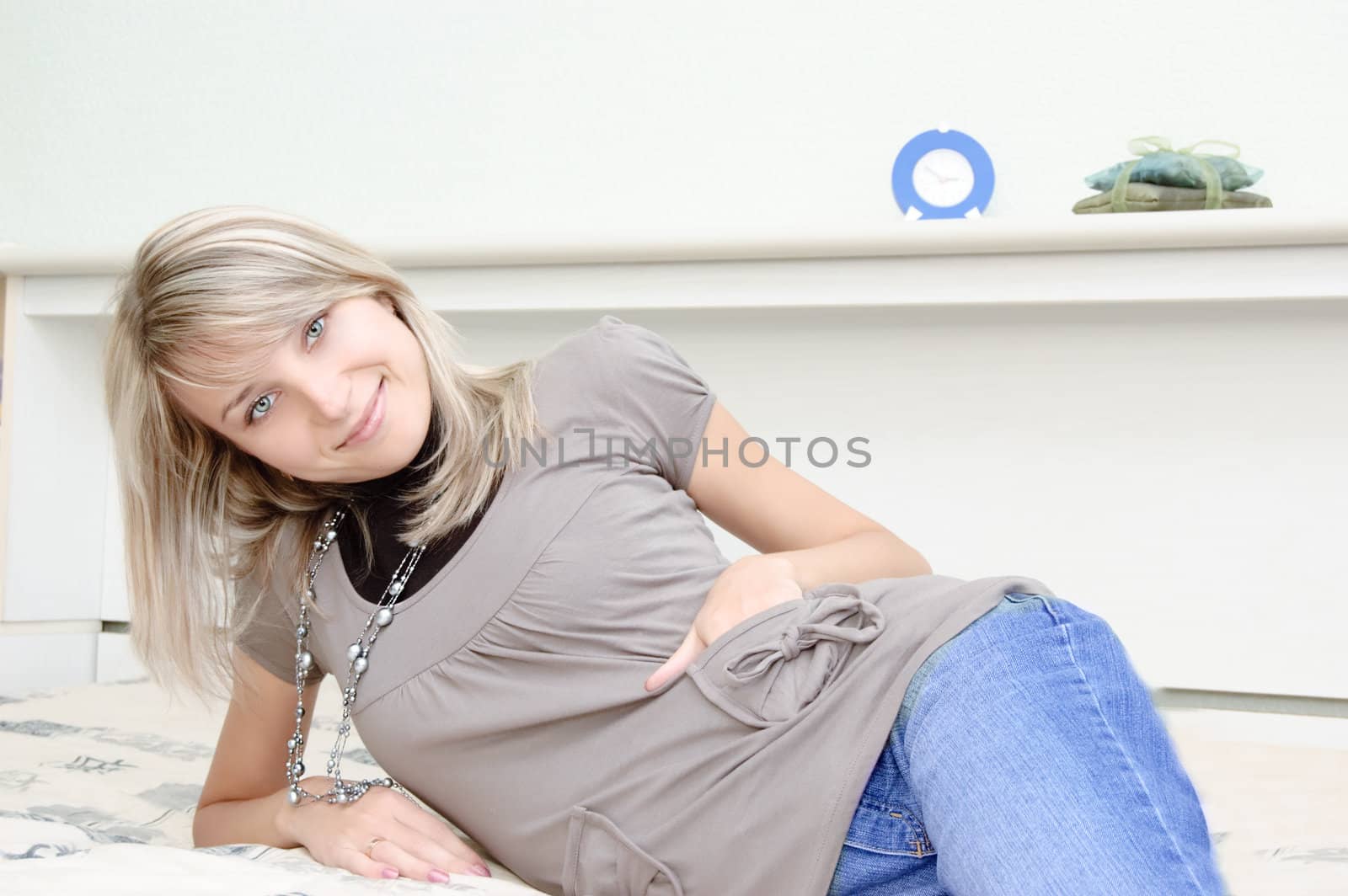 Pretty woman smiling and lying on bed