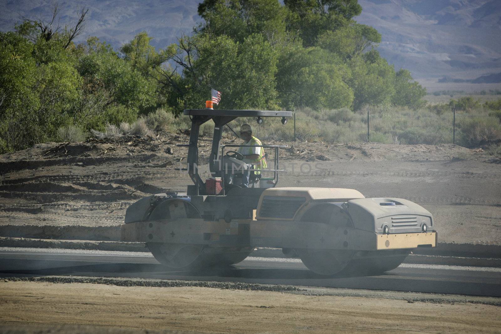 steamroller flatens fresh road surface