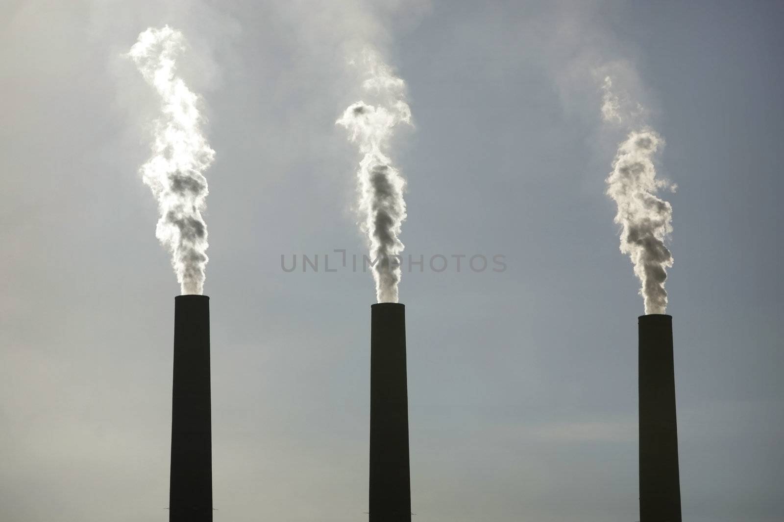 three smoking chimneys of a power plant