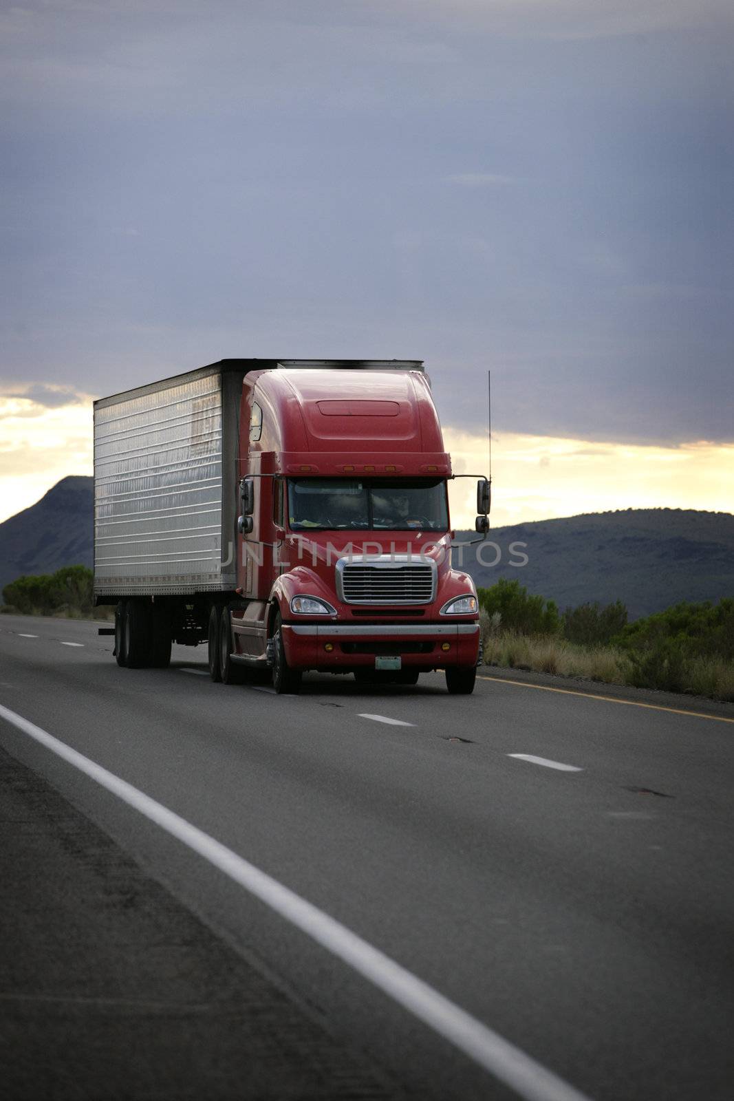 truck driving on a freeway at sunset