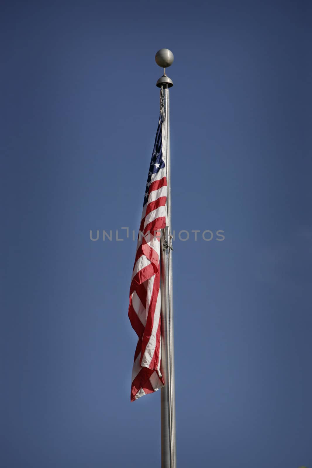 american flag hanging down with blue sky 