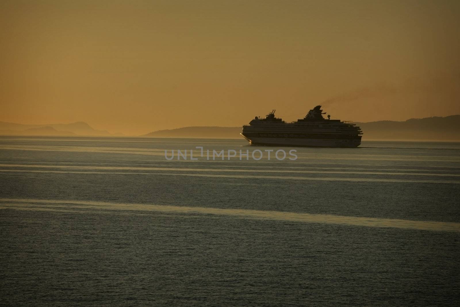 cruise ship at sunset with mountains in background