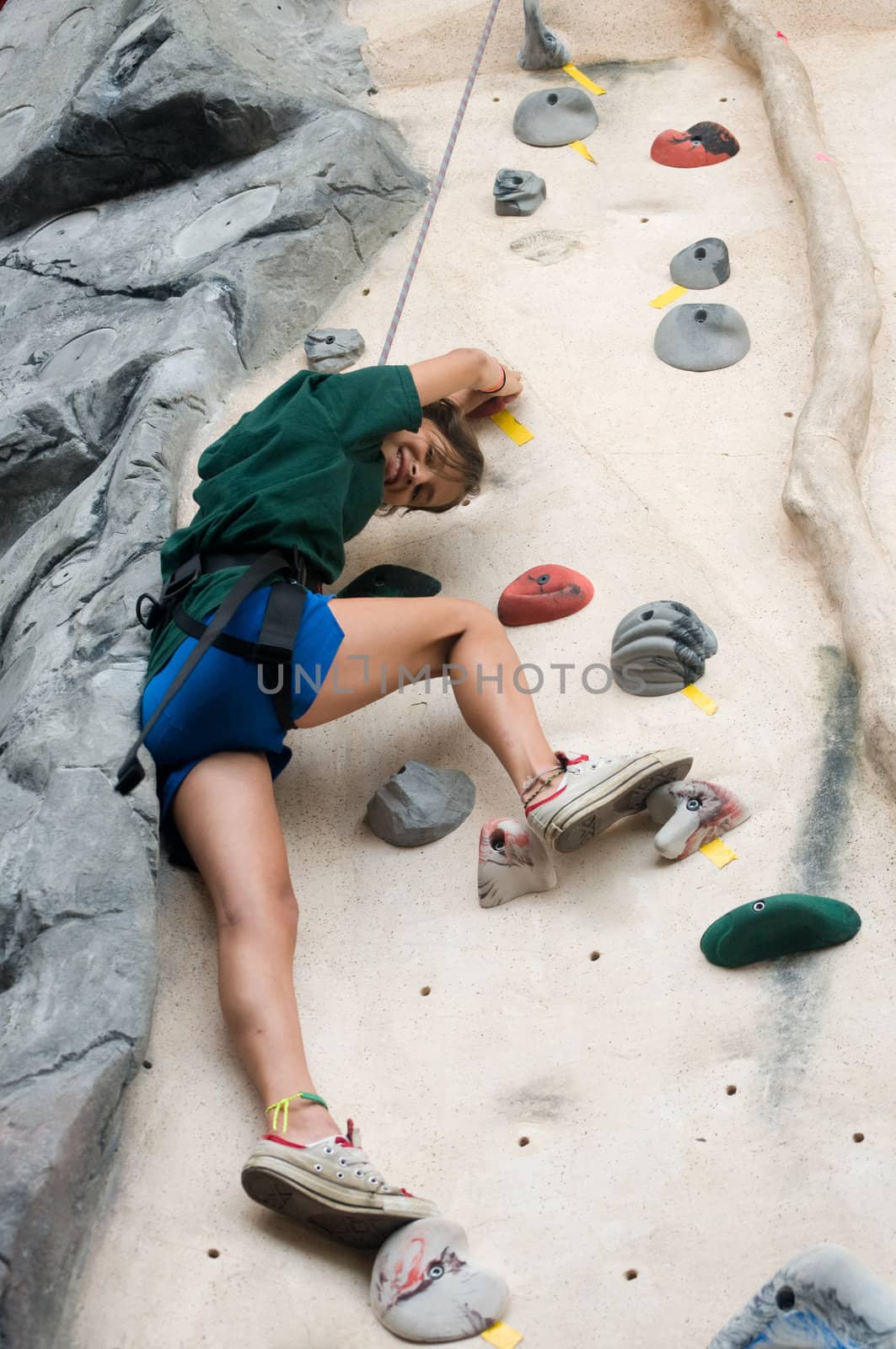 Teen looking down from high up on an artificial wall