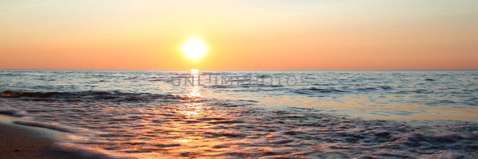 Panoramic view of waves washing ashore at sunset along beautiful Lake Superior.