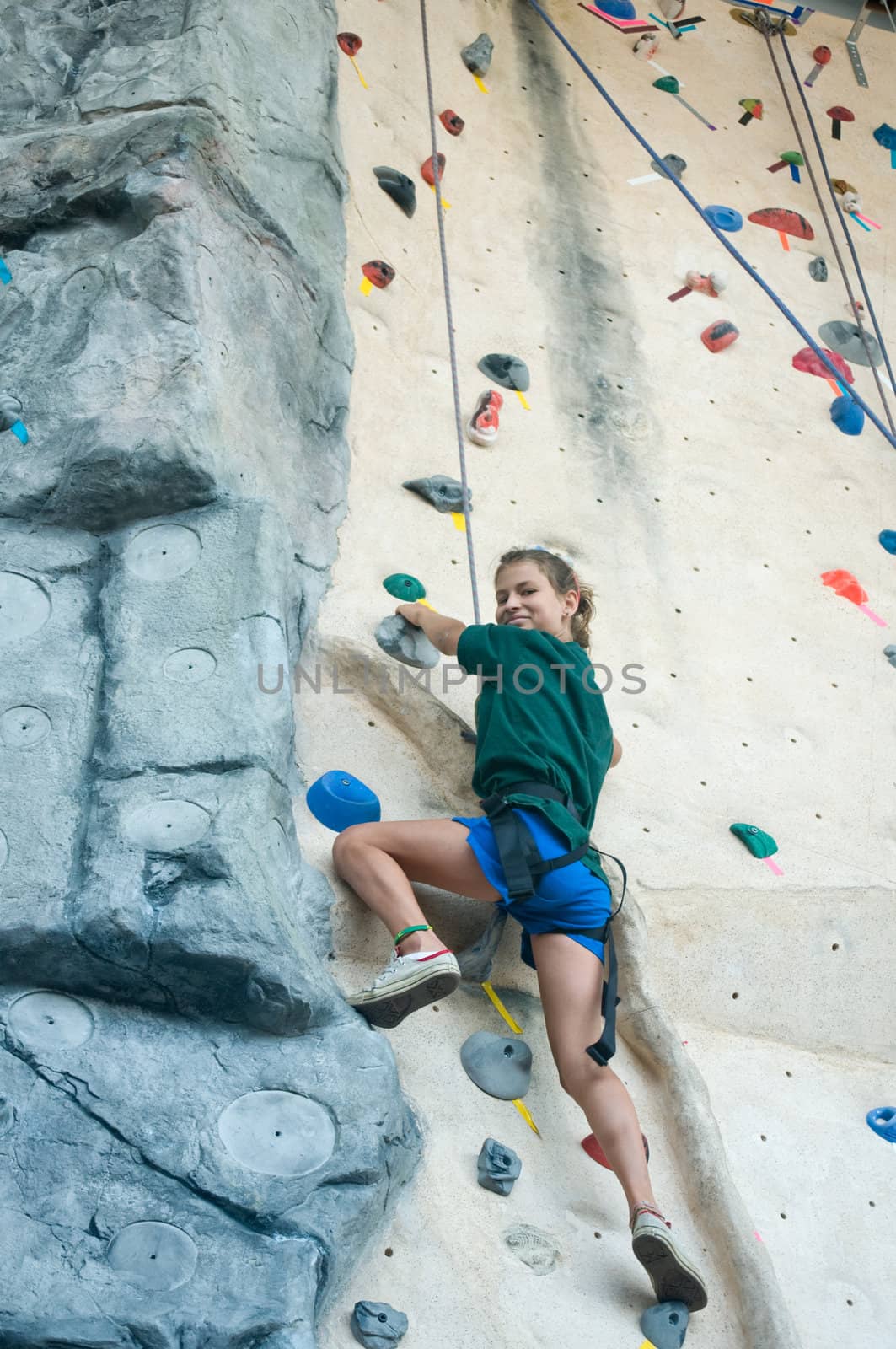 Teen looking proud  as she climbs an artificial wall