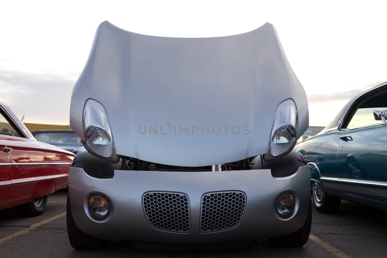 A beautiful sports car with its hood open and headlights looking down