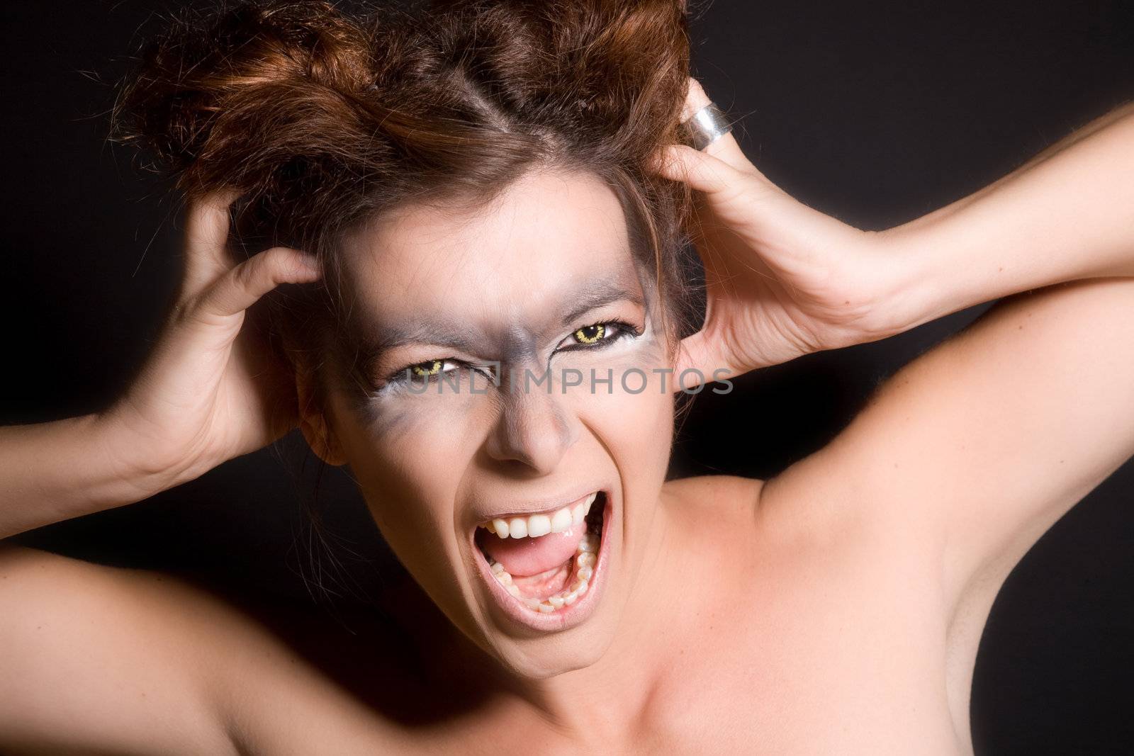 Woman with wolf eyes grasping her head and screaming