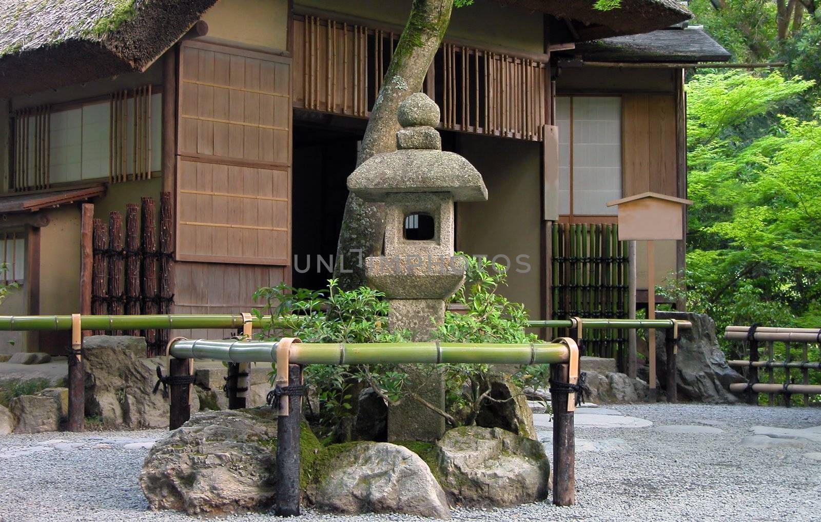 Very traditional Japanese tea house with stone lantern in front of it.Location:Golden Temple garden,Kyoto,Japan          