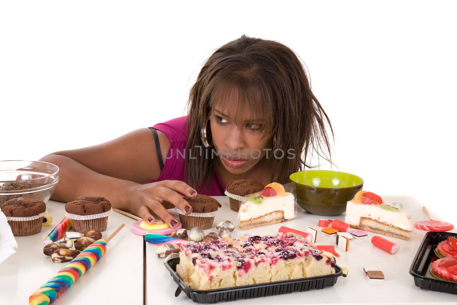 Pretty black girl looking very greedy at all the sweets in front of her