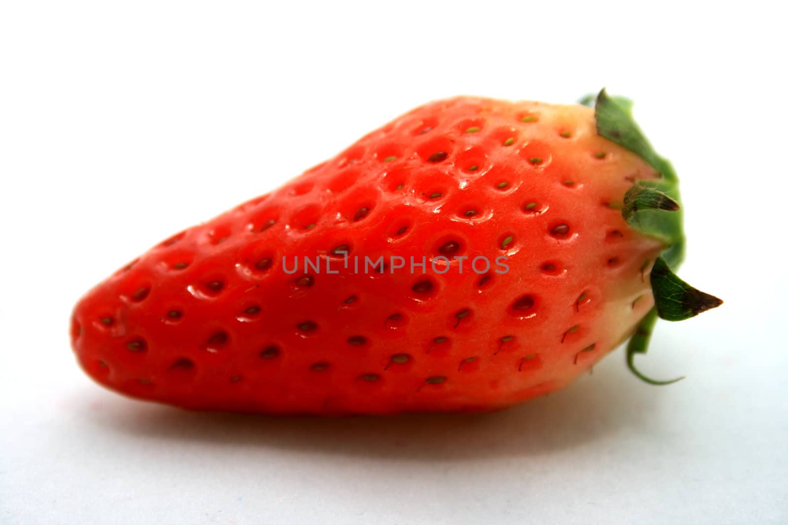 A brightly red strawberry on a light background