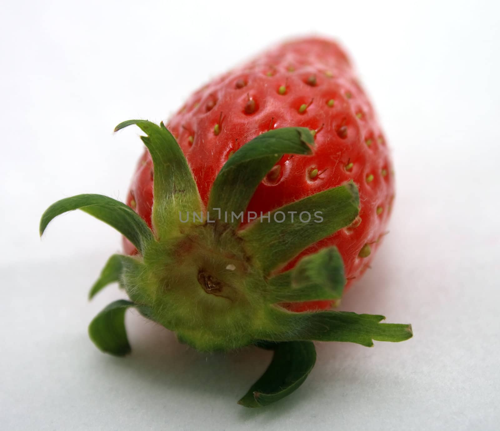 A brightly red strawberry on a light background