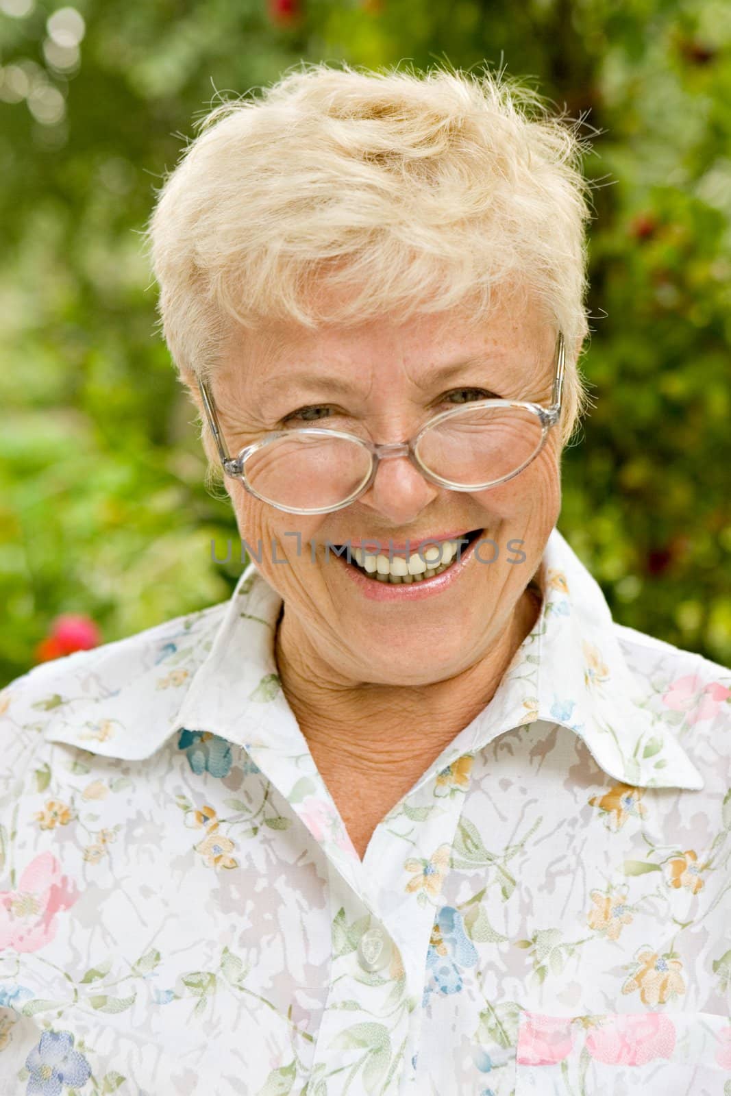 Portrait of the elderly laughing woman in glasses
