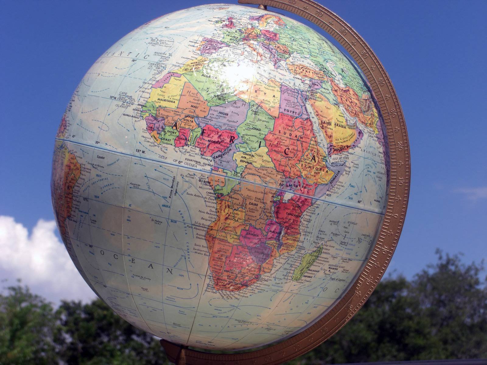 A globe stands up tall against a blue sky