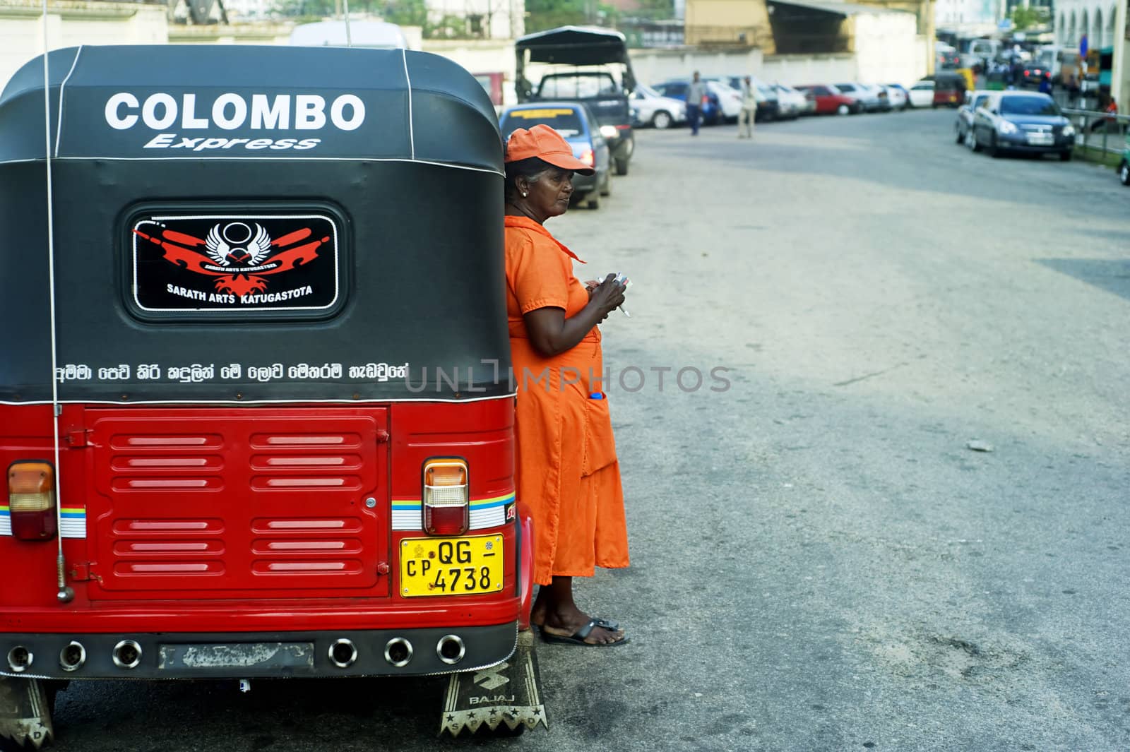 Colombo, Sri Lanka - February 22, 2011: Worker of Sri Lankan traditional taxi(tuk-tuk) waiting for clients.