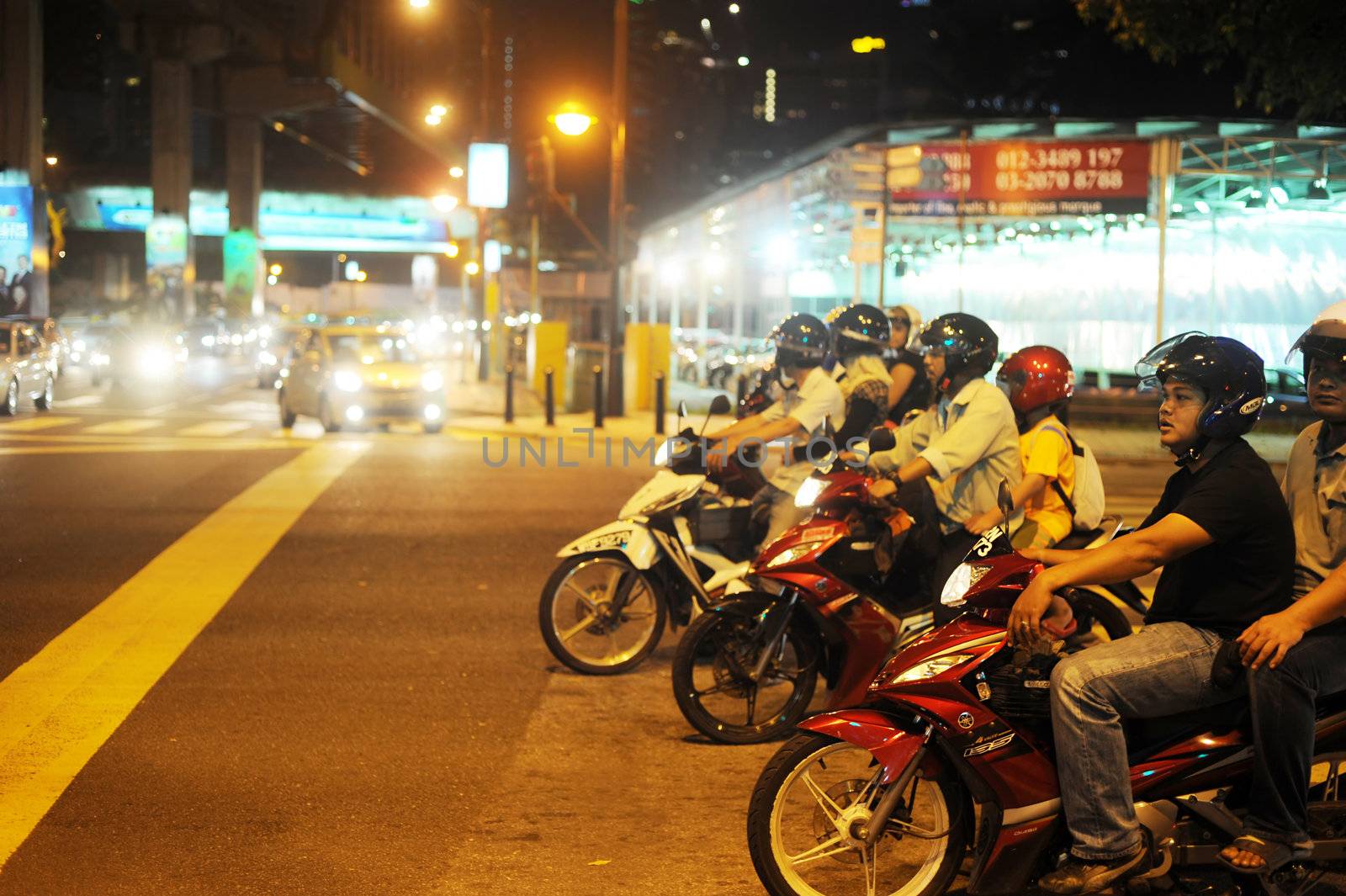 Kuala Lumpur, Malaysia - March 03, 2011: Motorcyclists stading on junction in Kuala Lumpur in the evening.