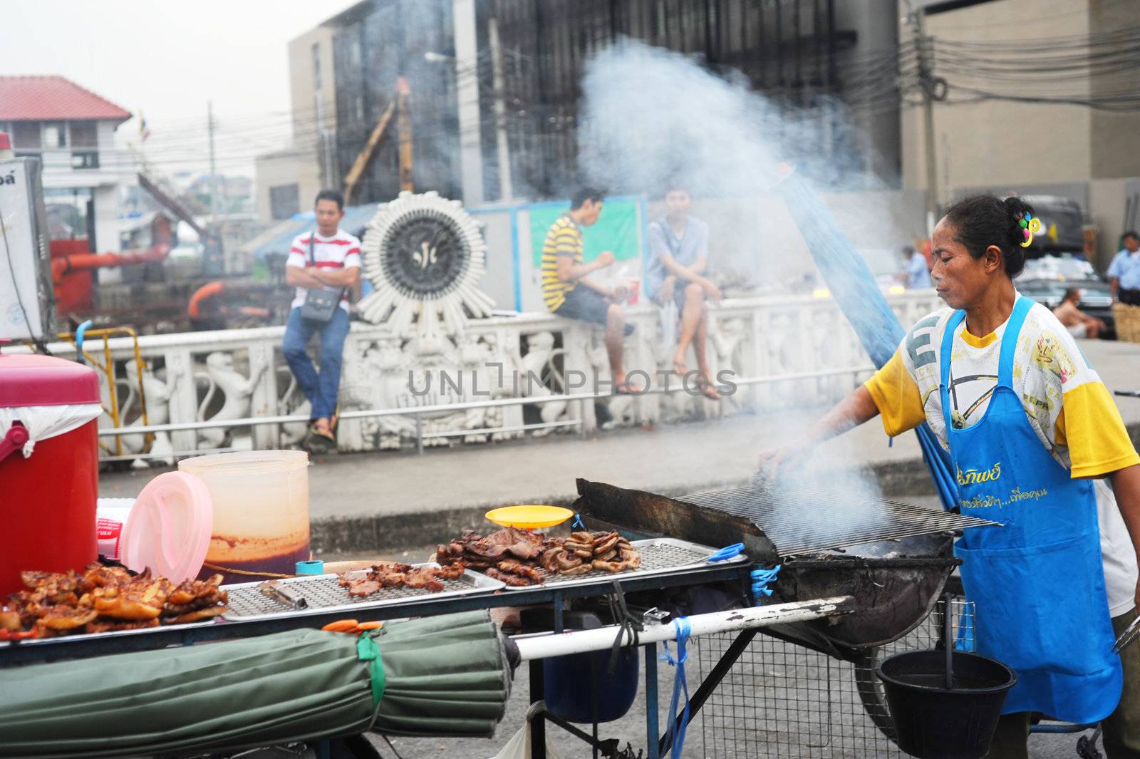 Bangkok, Thailand - March 25, 2011: Woman cooking traditional Thailand fast food on the street