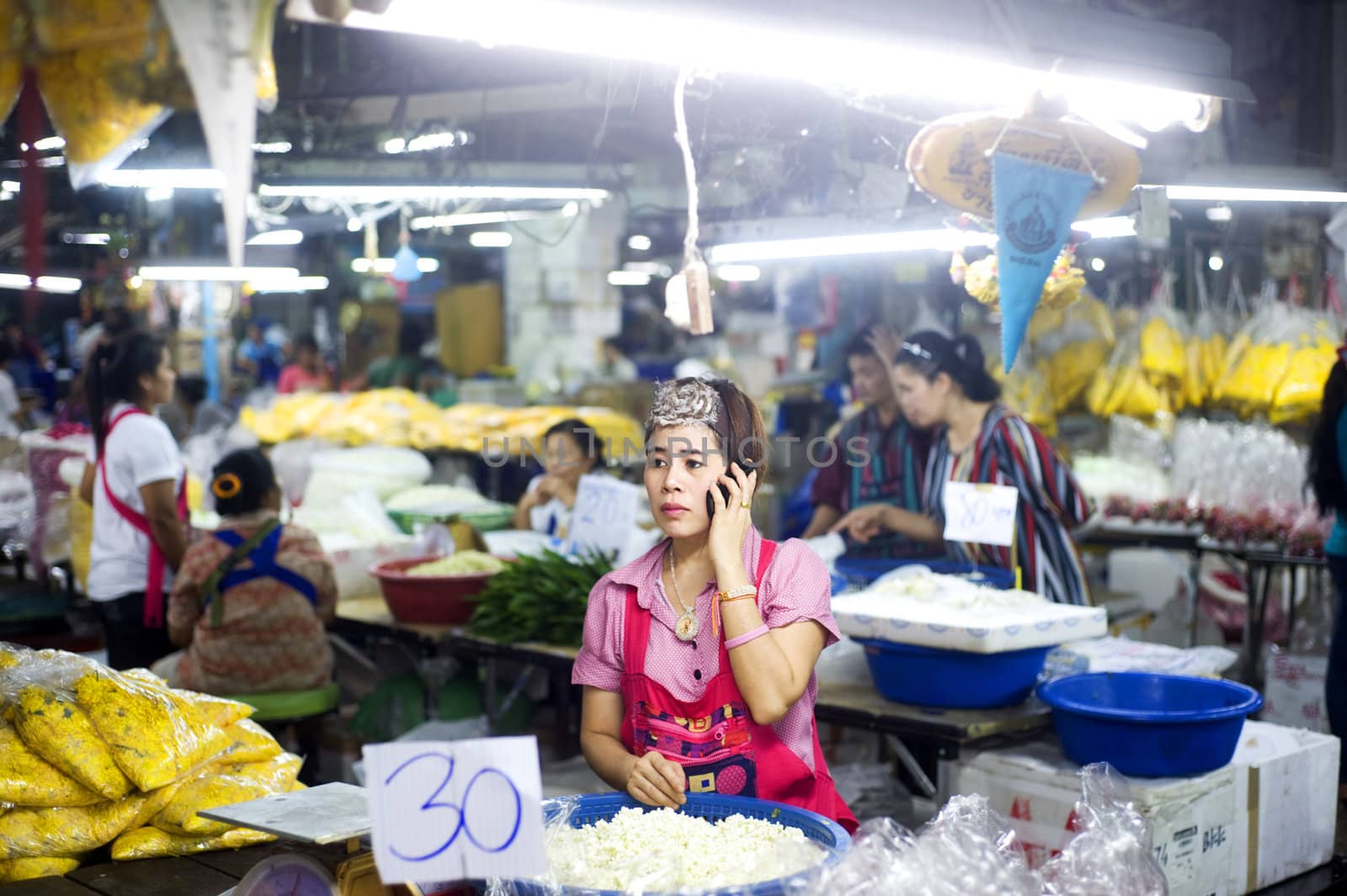 Bangkok, Thailand  -  March 15, 2011: Seller using her smartphone at local market in Bangkok Chinatown .Bangkok�s Chinatown is a popular tourist attraction and a food haven