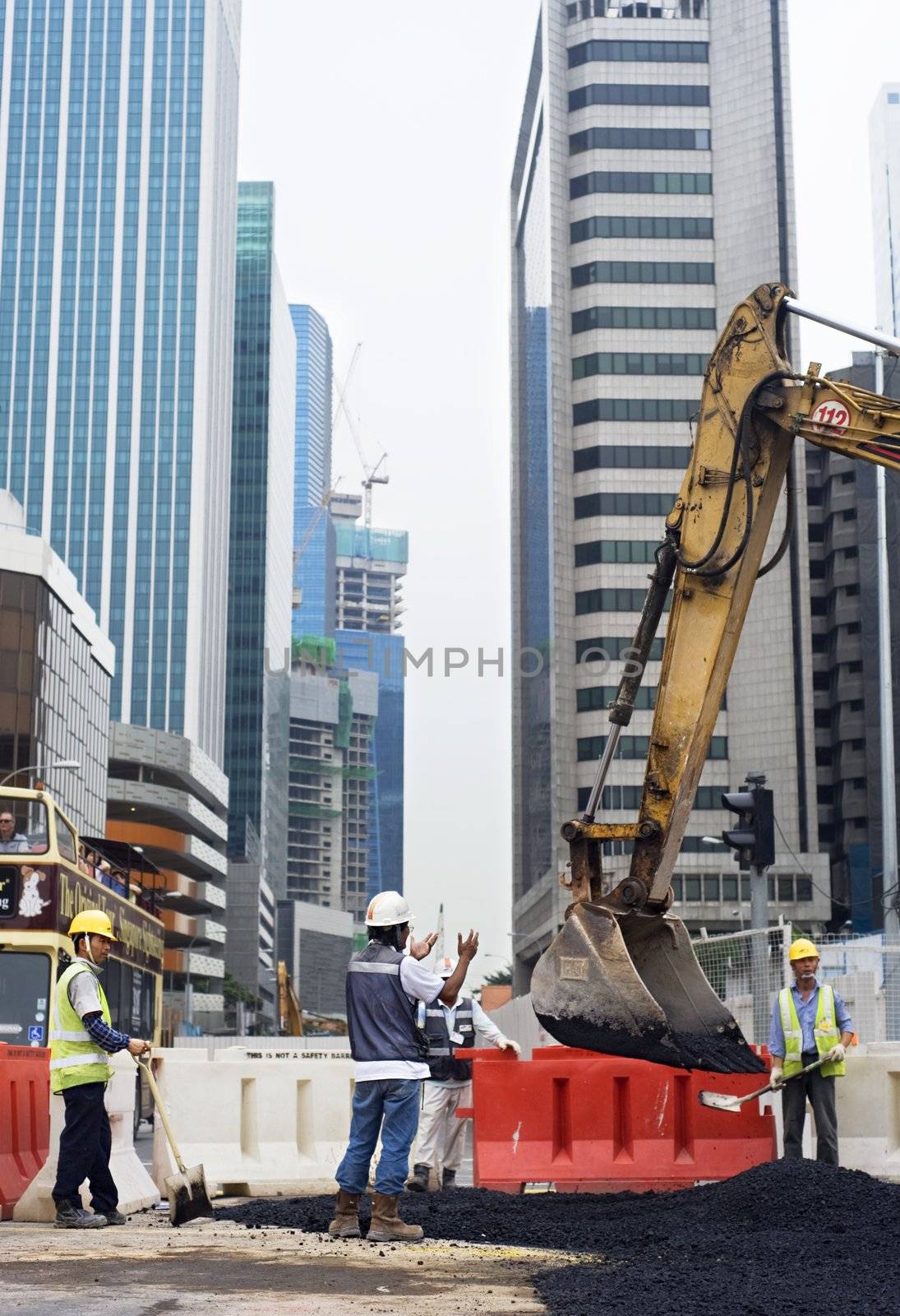 Singapore, Republic of Singapore - May 02, 2011: Workers repairing roads on the one of Singapore city street