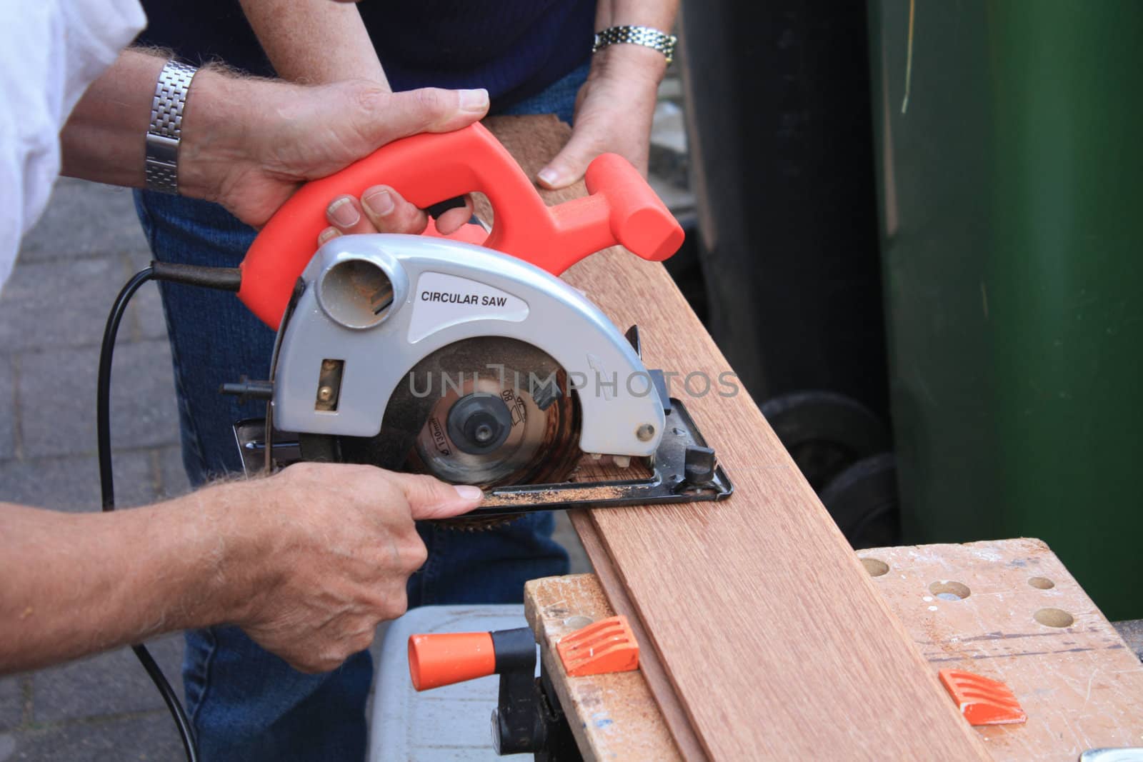 construction worker cutting wood with circular saw by studioportosabbia